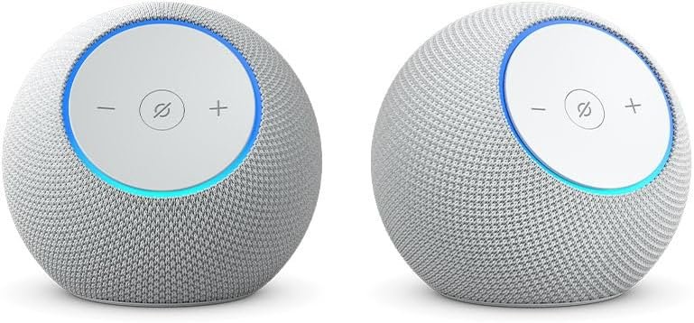 Echo Studio and Echo Dot Max smart speakers placed on a wooden table showing size dimensions comparison.